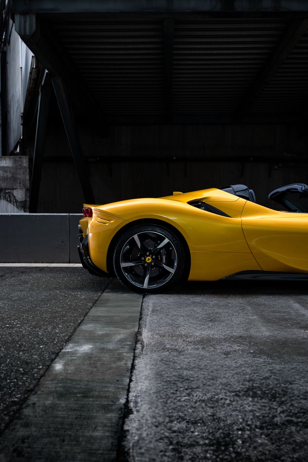 Ferrari SF90 Spider amarillo de perfil bajo techumbre oscura