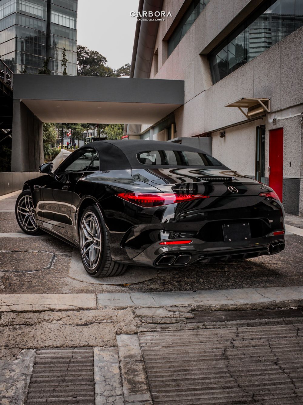Mercedes-AMG SL 55 negro, tres cuartos trasero en el acceso de un edificio