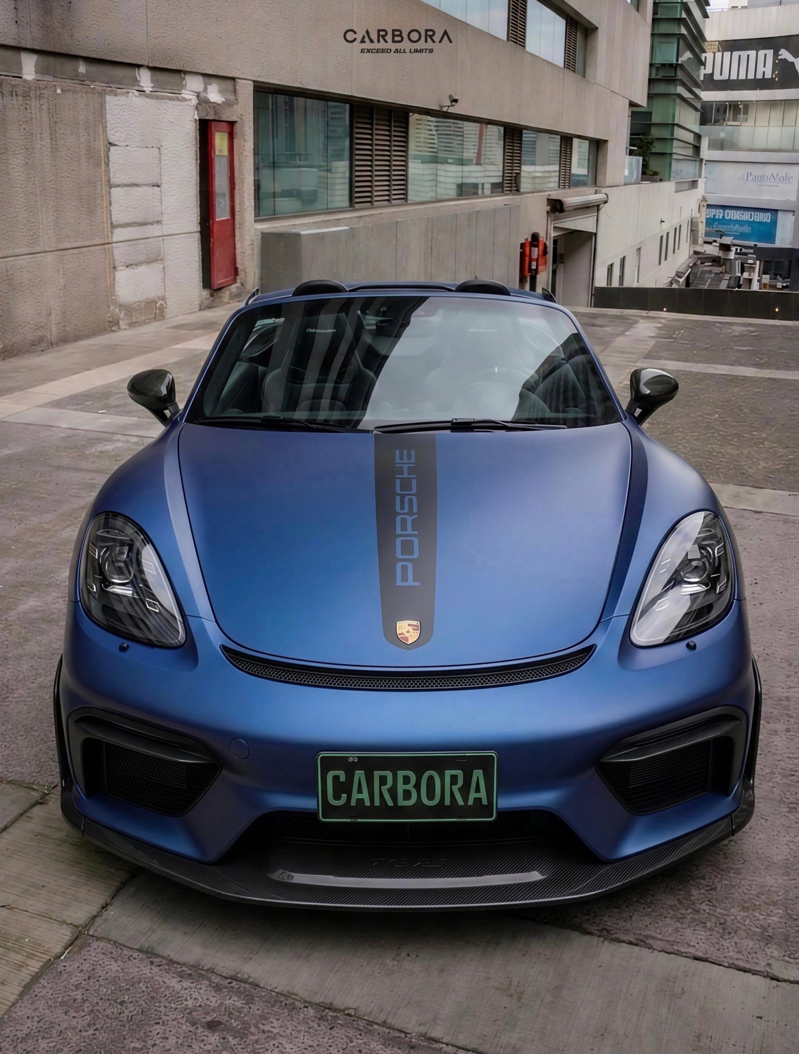 Porsche 718 Boxster con wrap azul, fascia tipo GT4 RS y lip de carbono.