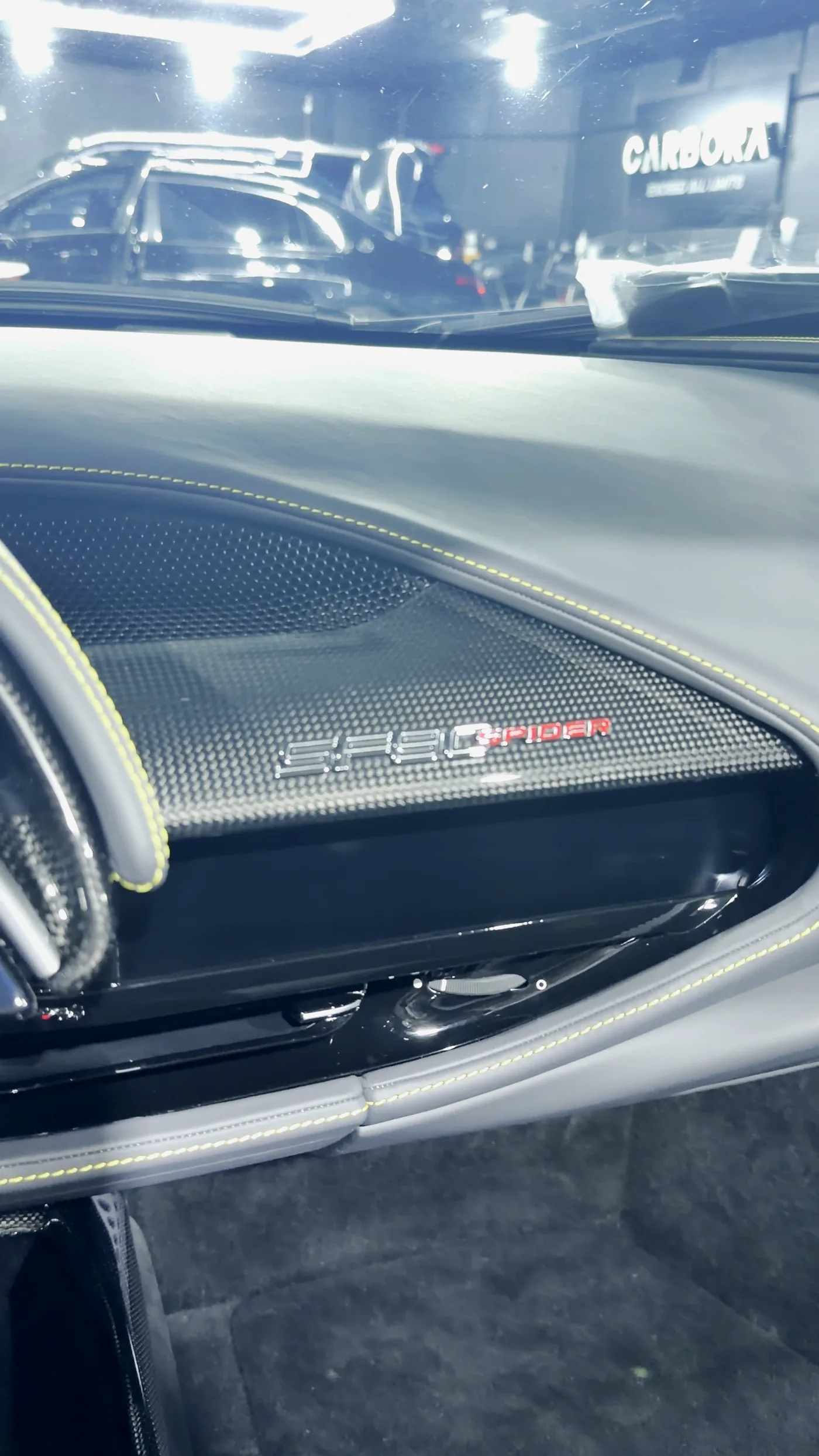 Tablero de fibra de carbono del SF90 Spider con la firma del modelo y costuras amarillas, fotografía real